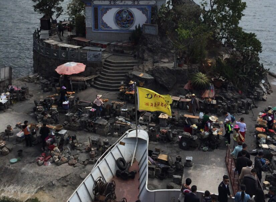 云南一个寺庙,被小吃摊包围,墙都被烧烤的油烟熏黑了!