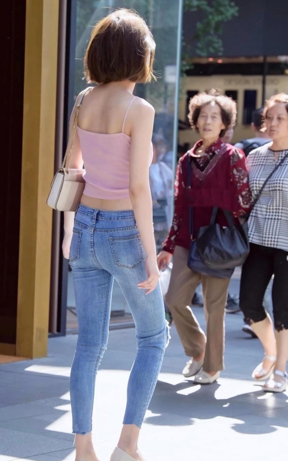 气质小姐姐蓝色紧身牛仔裤搭配粉色吊带装，看似简单背影其实并不