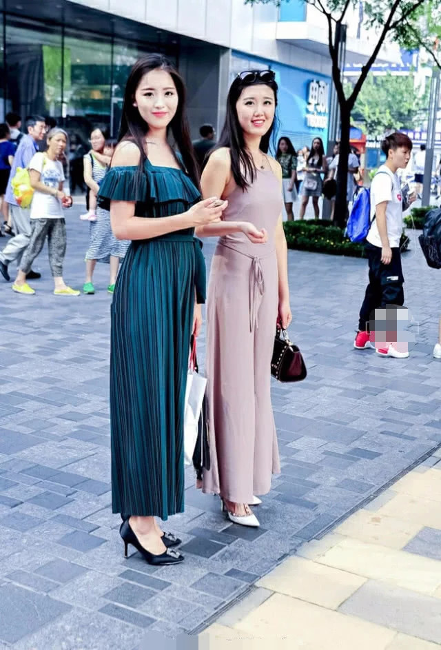 优雅时尚姐妹花漫步街头，修身长裙显凹凸有致身材