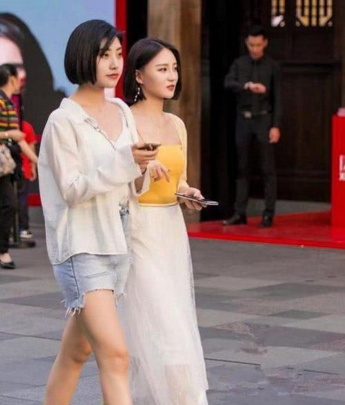  「面带微笑」美女时尚街拍：面带微笑的美女，一件黑色的上衣配黑色短裙，时尚美丽大方