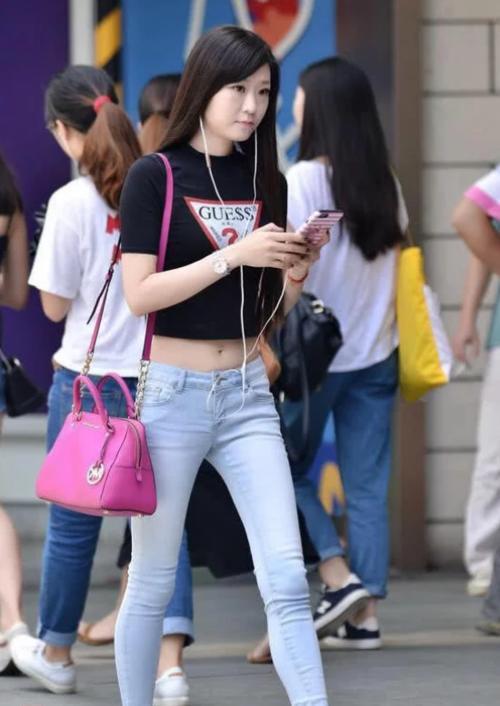 小姐姐上身搭配了一件灰色的紧身运动背心，露脐装搭配紧身牛仔裤