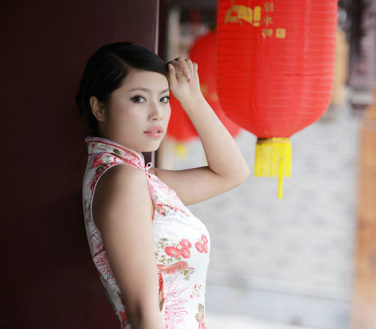 一个笑容怡人的民族风情旗袍装美女