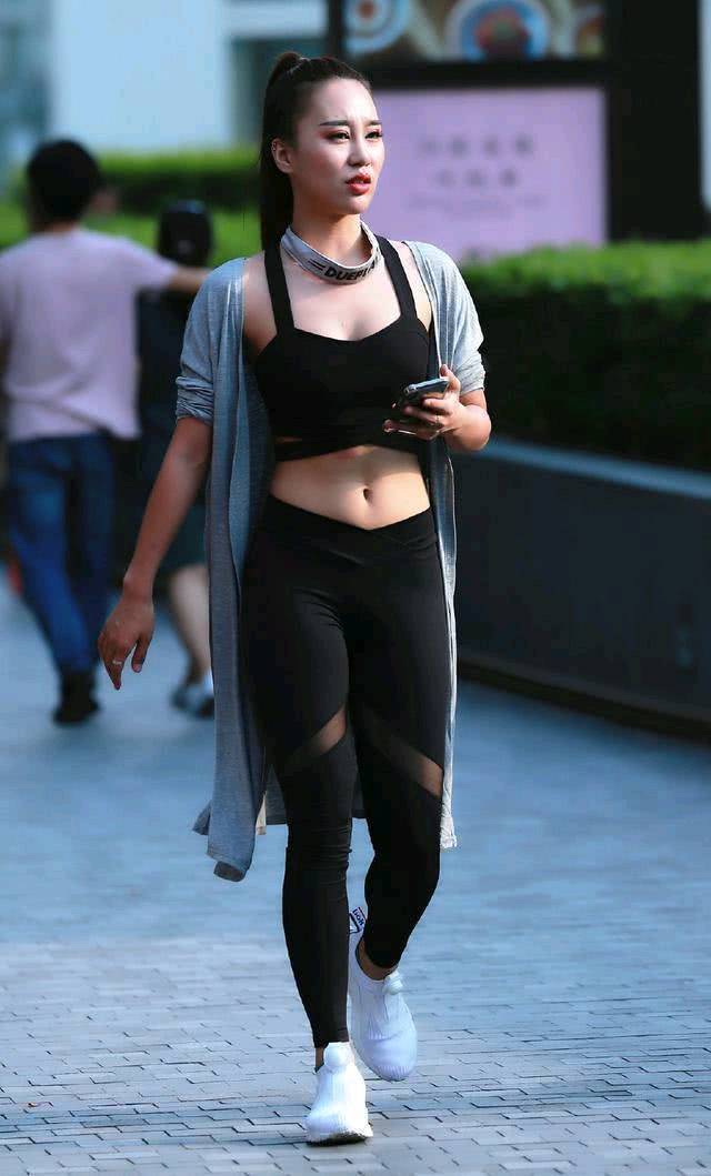 街拍，美女身穿黑色运动型内衣，搭配黑色牛仔热裤，身材丰满！