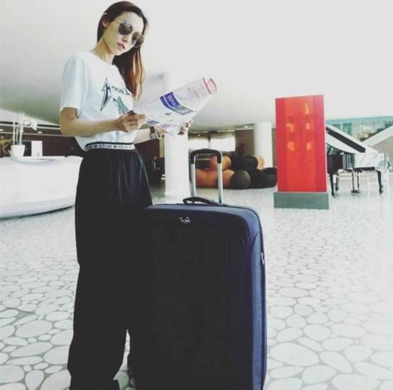 范玮琪休闲装扮现身机场 甜笑撩发元气满满