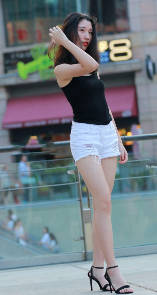 时尚小姐姐穿黑色吊带上衣勾勒纤瘦好身材,低头一笑很温柔