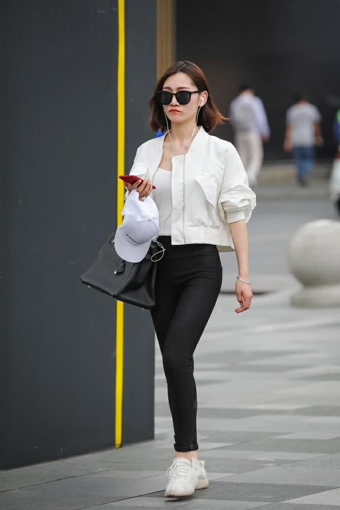 街拍：气质小姐姐紧身裤时尚美腿，一边走一边嘟嘴撩发萌态十足