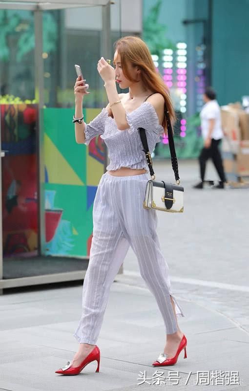 美女手持香烟在街上，成为独特的靓景