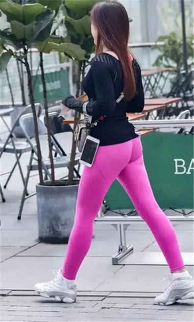 长发飘飘小姐姐身穿粉色运动紧身裤搭配黑色长袖衫显出曲线身材，