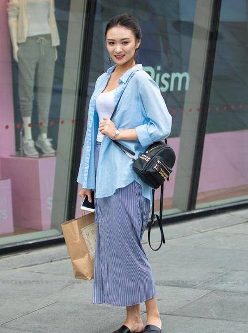 路人街拍,左边小姐姐穿的是黑色吊带的紧身裙,很有活力的穿搭