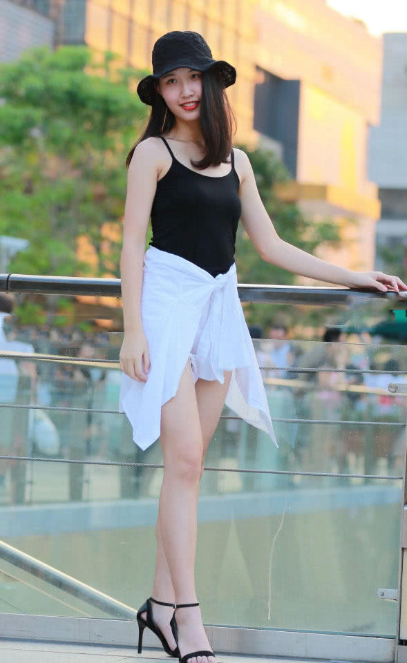 时尚小姐姐穿黑色吊带上衣勾勒纤瘦好身材,低头一笑很温柔