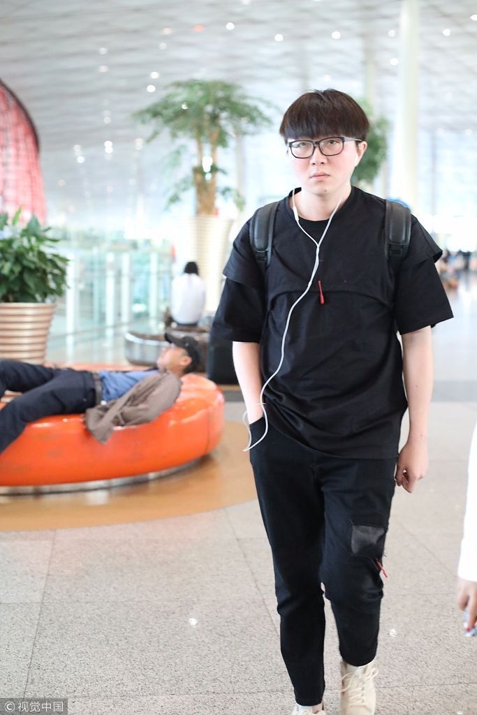 毛不易全黑look扮酷机场边走边听歌 “苹果脸”配“西瓜头”自带
