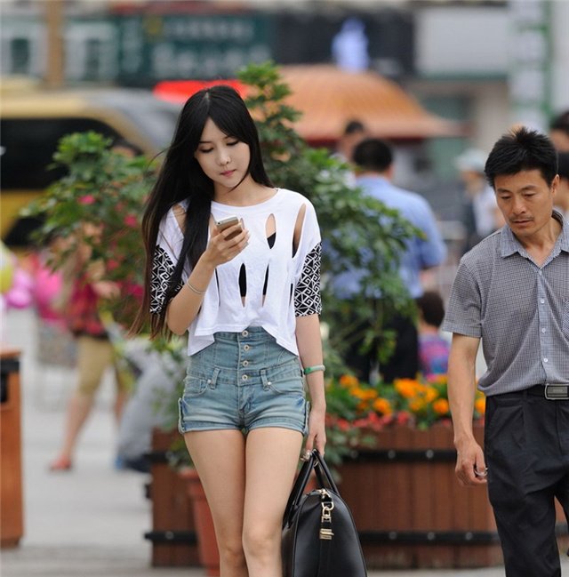 街拍美女镂空T恤高腰短裤大长腿女神