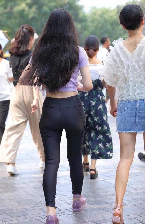 美丽的小姐姐搭配的一件紧身裤，脚口很细的设计大秀了曲线双腿