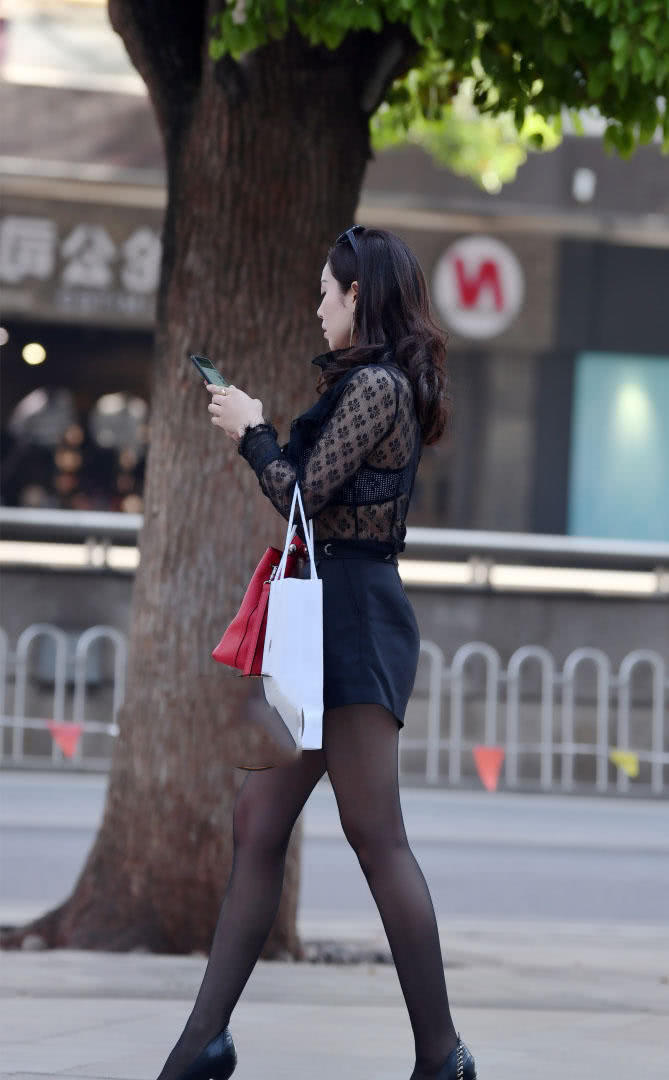 成熟小姐姐穿黑色丝袜加上高跟鞋勾勒曼妙身姿，走在路上很吸睛