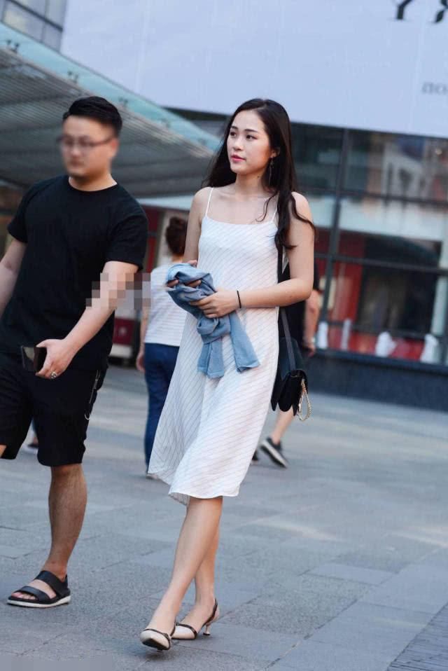 街拍美女:气质小姐姐吊带连衣裙秀白皙美腿，优雅的弯腰吸睛无数