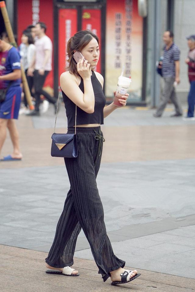 路人街拍：黑背心和牛仔短裤的穿搭，秀出小姐姐高挑迷人的身材