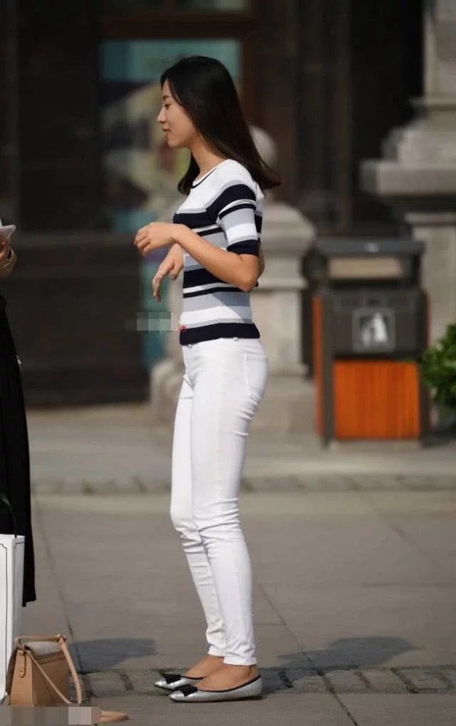 街拍美女:白色牛仔裤绷出紧翘精致的身材,轻甩头发霸气十足