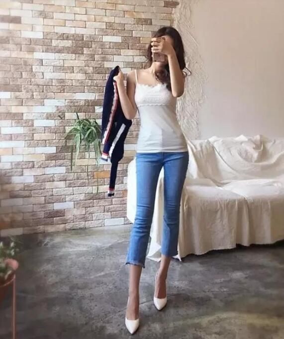 紧身牛仔裤修饰出美女身材曲线感，显现的时尚靓丽又有魅力