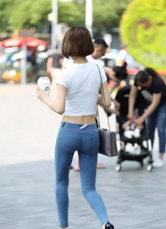 街拍气质小姐姐紧身牛仔勾勒出厚实的臀部，身后的大叔看呆了