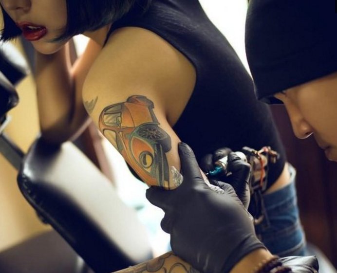 美女纹身时候的表情什么样?和纹身师形成鲜明的对比