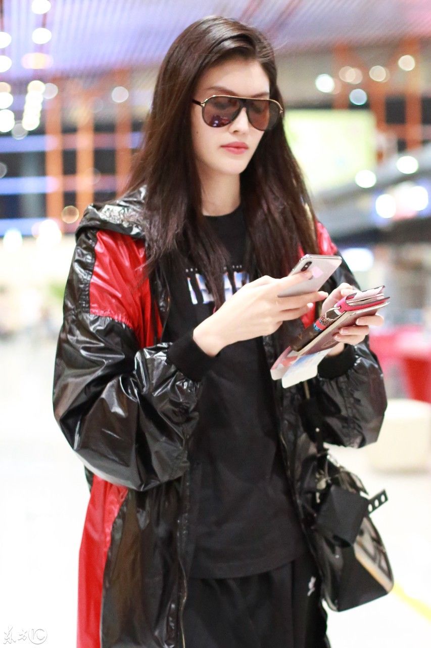 超模何穗现身北京机场，一身雨衣，难掩美腿