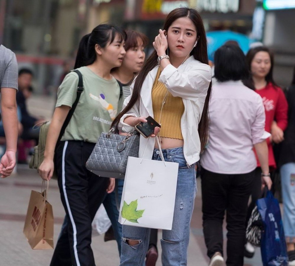街拍的牛仔裤露脐装长发美女