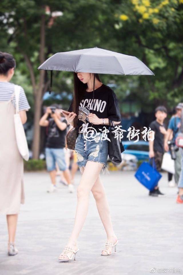 路人街拍:小姐姐很漂亮,白衬衣搭配黑短裤,秀出完美腿型