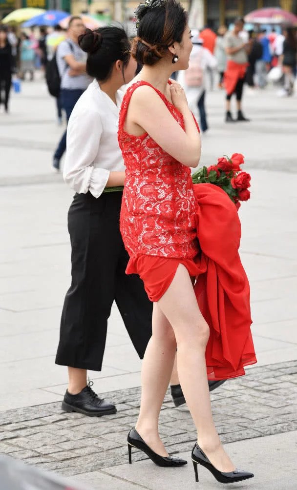 小姐姐穿红色嫁衣撩起裙摆秀出一双白皙美腿，笑容很幸福