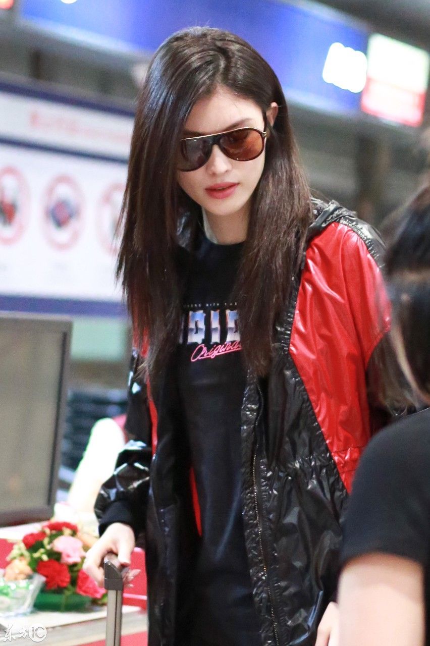 超模何穗现身北京机场，一身雨衣，难掩美腿