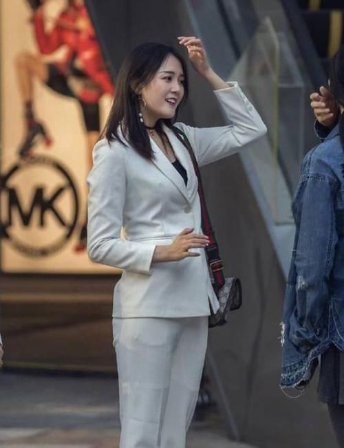  #出自己的时#潮范儿女神来了，街拍：面带微笑的小姐姐，一件白色上衣配漏洞牛仔裤，青春靓丽范
