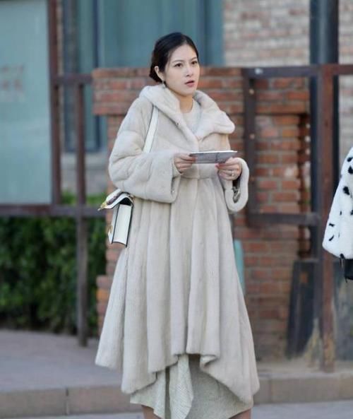  「休闲裤」街拍：身材高挑的美女，一件米黄色上衣配橘红色休闲裤，气质十足