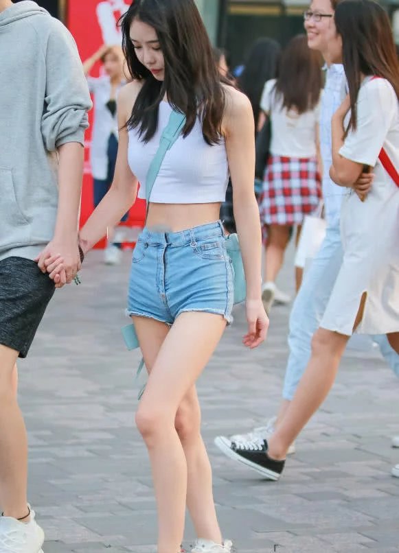 性感小姐姐吊带漏脐装搭配超短牛仔裤，丰润的双腿很吸睛，值得一