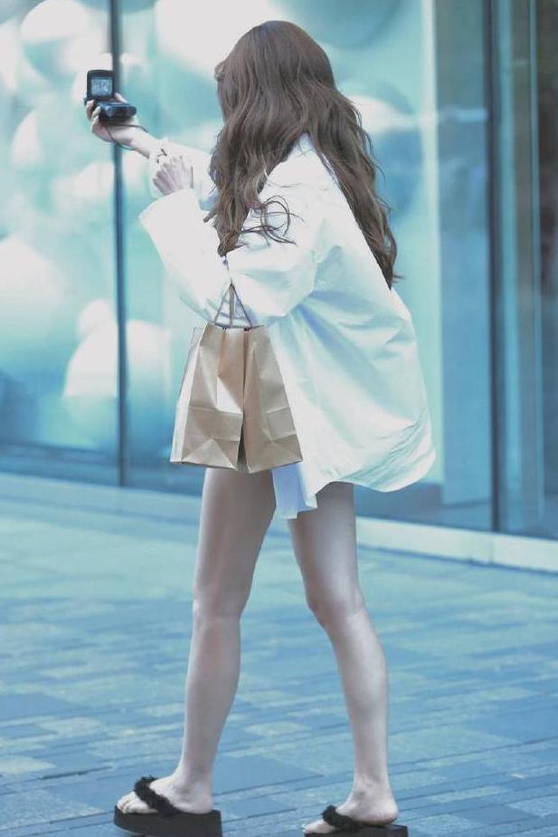 街拍：活泼可爱的小姐姐，穿毛边热裤还不断高抬美腿，显腿长？