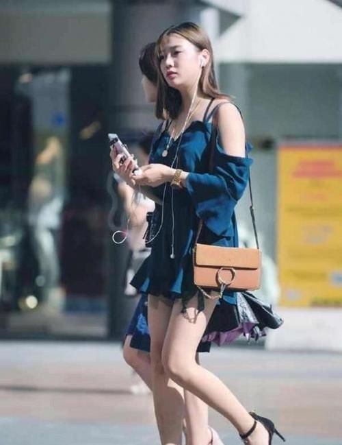  『长筒靴』路人街拍：美女腿型非常瘦，搭配黑色的长筒靴，格外的性感有魅力