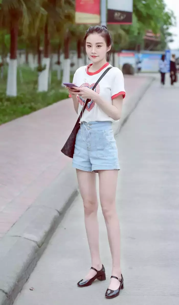 路人街拍，时尚的无袖上衣搭配干练的牛仔裤，打造出你的窈窕身姿