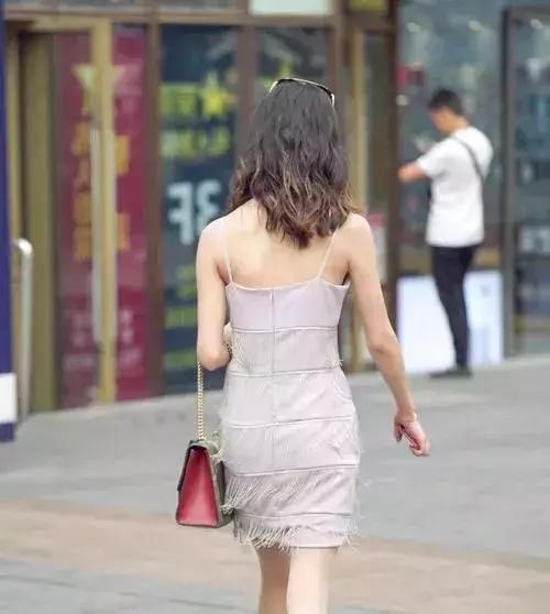 路人街拍:穿着吊带的连衣裙，勾勒出曼妙的身姿，非常的美丽动人