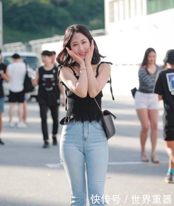  「气质」街拍：面带笑容的美女，一件黑色背心配浅色牛仔裤，
