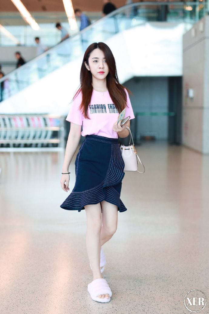 王晓晨穿粉色T恤搭配黑色荷叶边半身裙现身机场，少女感十足