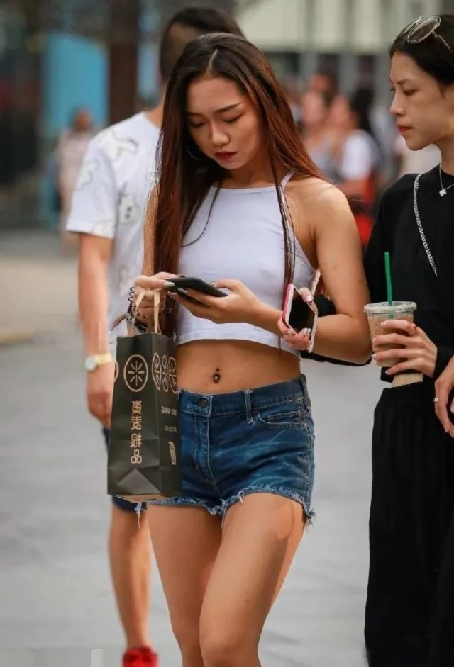 辣妹热裤秀笔直双腿和健美蛮腰，真空穿着背心，时尚又俏皮