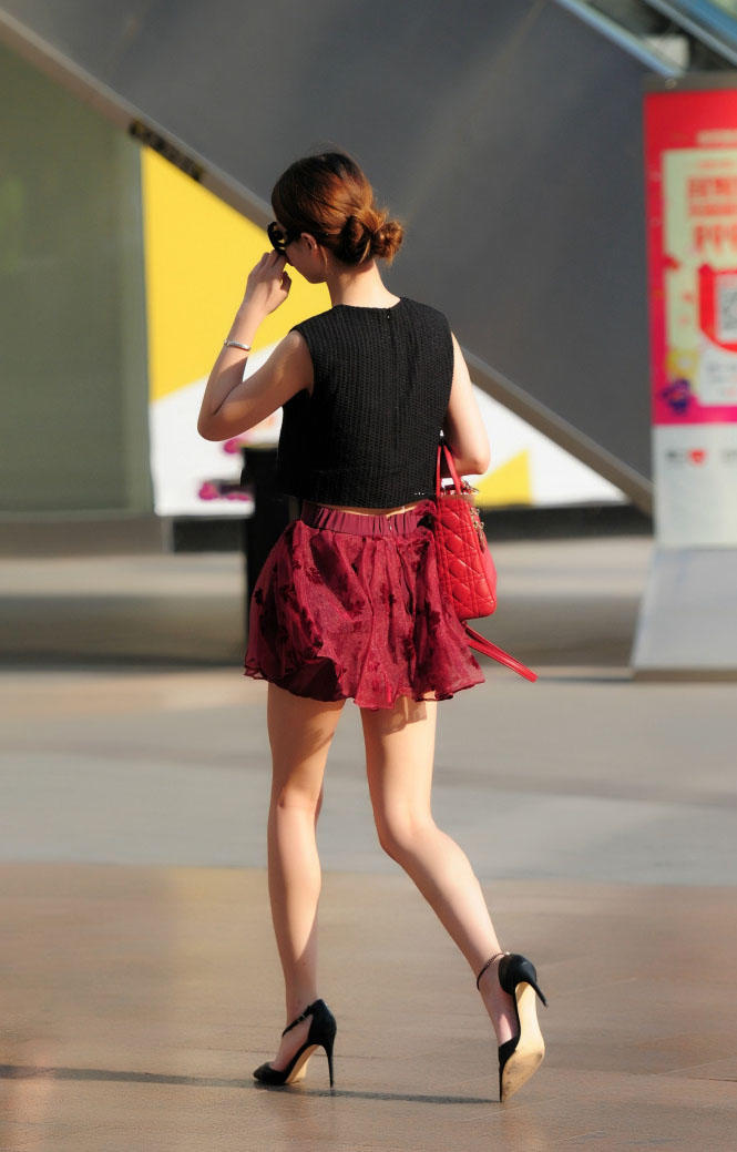 成熟小姐姐穿红色褶皱裙秀出纤长白皙美腿，长腿搭上细高跟很迷人