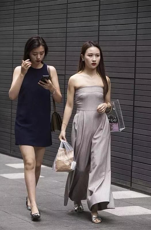 美女上身穿着露脐背心和深色外套，这么穿真的不热吗?