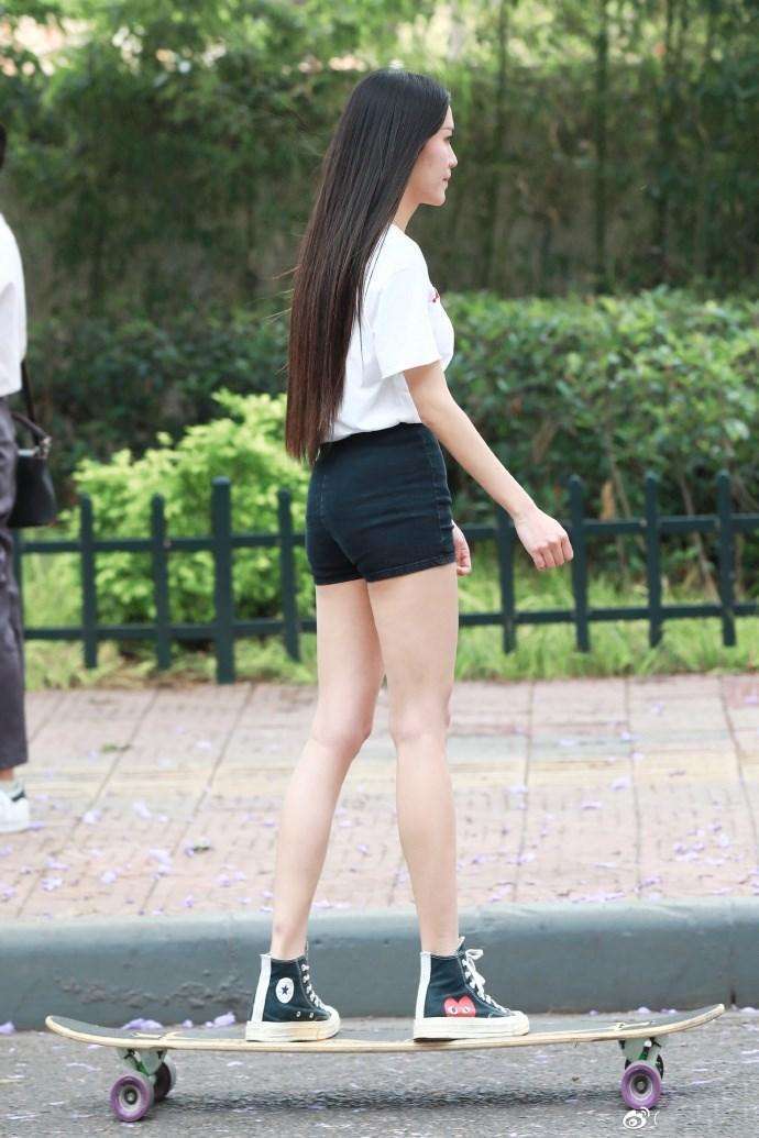 路人街拍，姑娘选择的这款短裤属于修身款，展示出浓浓的性感范