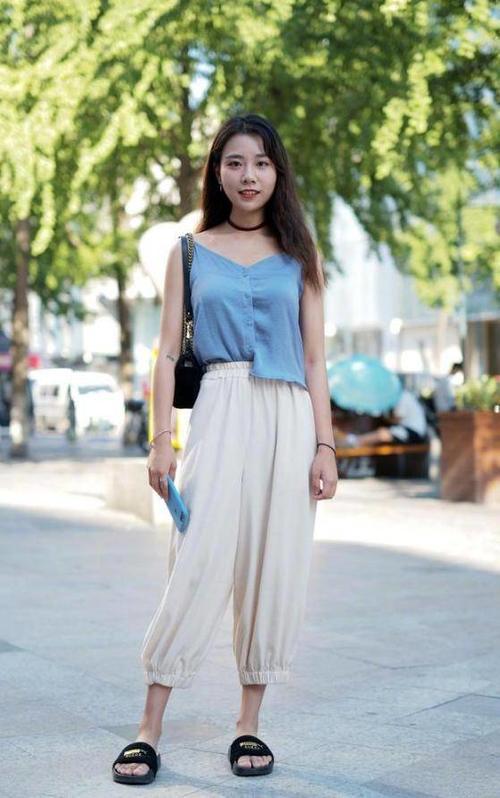 路人街拍,左边小姐姐穿的是黑色吊带的紧身裙,很有活力的穿搭