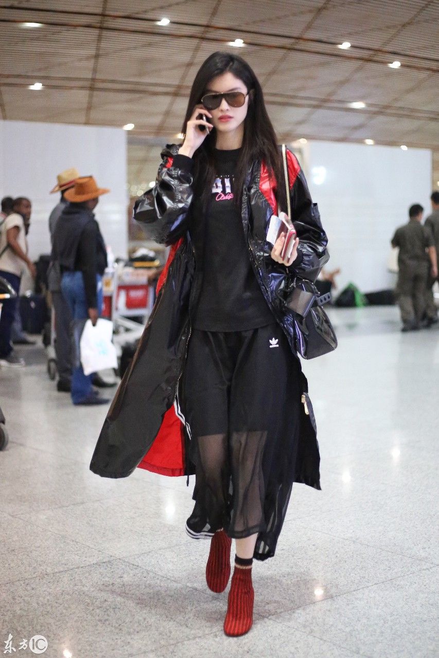超模何穗现身北京机场，一身雨衣，难掩美腿