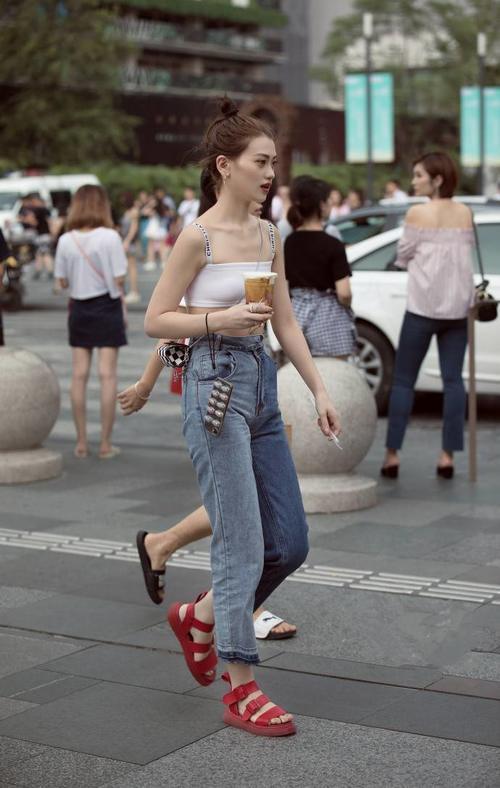 街拍，身材纤细的小姐姐穿露脐装配牛仔裤清凉又时尚，身姿倩丽