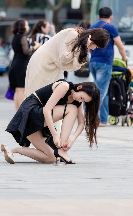 俏皮小姐姐嫌弃高跟鞋太高，与闺蜜当街换鞋，露出精美小脚丫