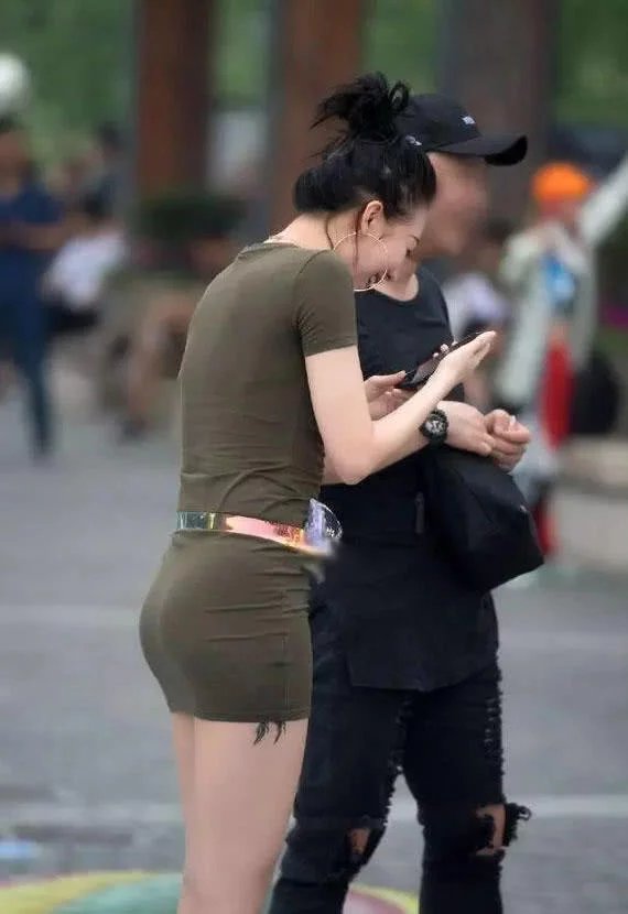 妙龄少妇紧身裙勾勒肥硕臀线当街秀身材，一旁被搭讪的小哥哥都害