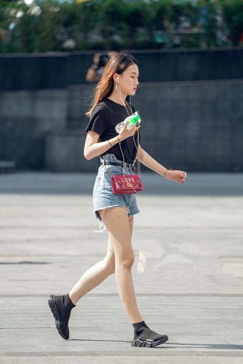 路人街拍，小姐姐脸上画着精致的妆容，看上去非常的迷人性感