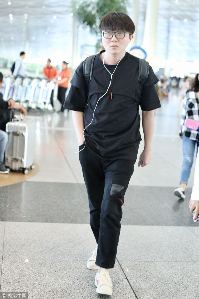 毛不易全黑look扮酷机场边走边听歌 “苹果脸”配“西瓜头”自带
