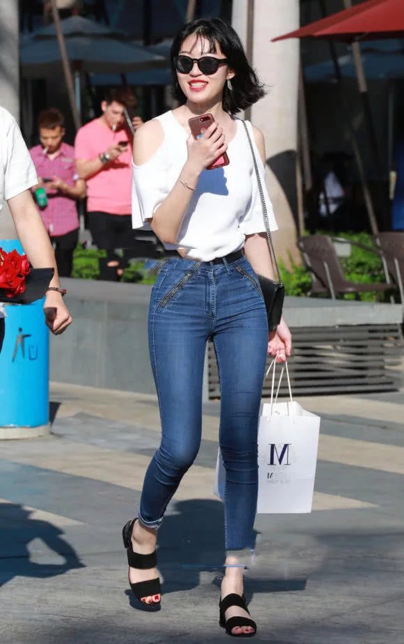 时尚小姐姐紧身牛仔裤勒出大长腿，身材凸凹有致